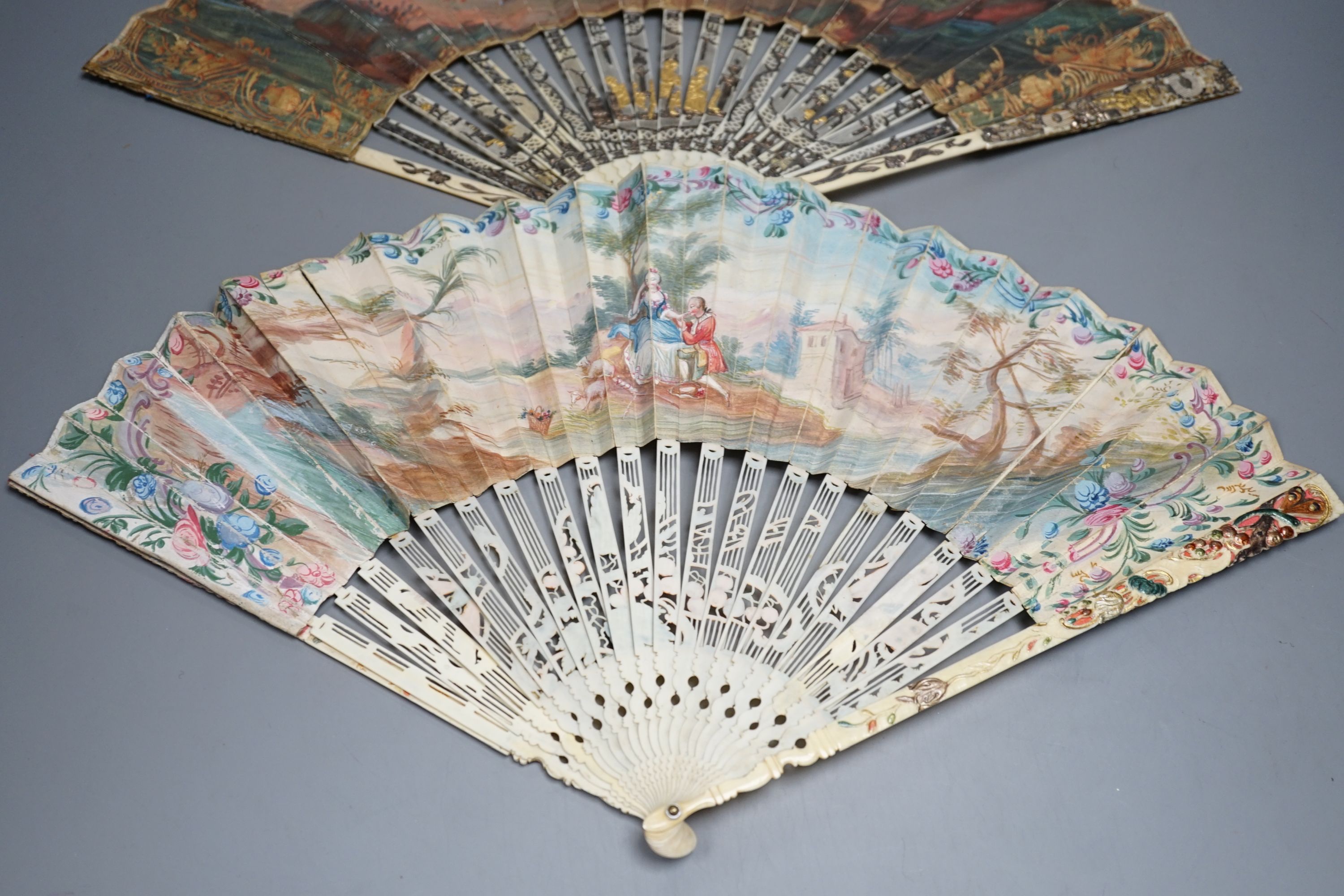 Two late 18th/early 19th century French gilded and silvered ivory and painted paper leaf fans